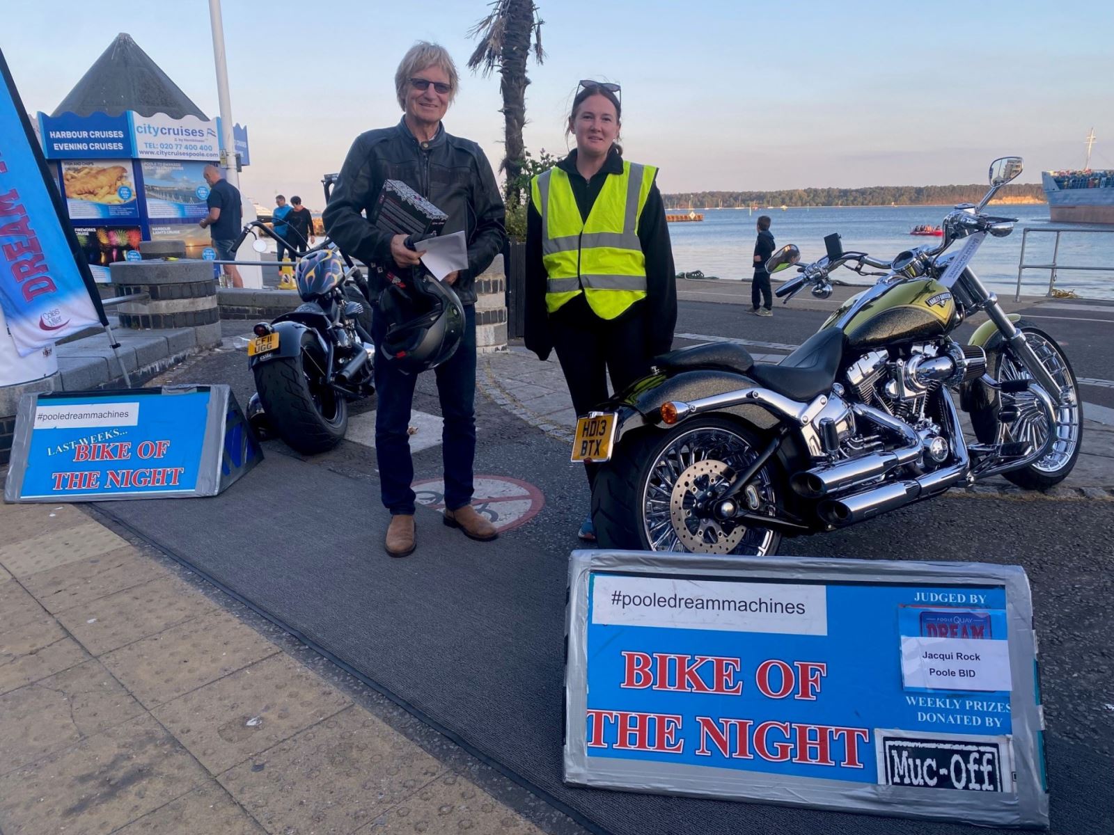 Man and woman posing with winning bike at Poole Quay 